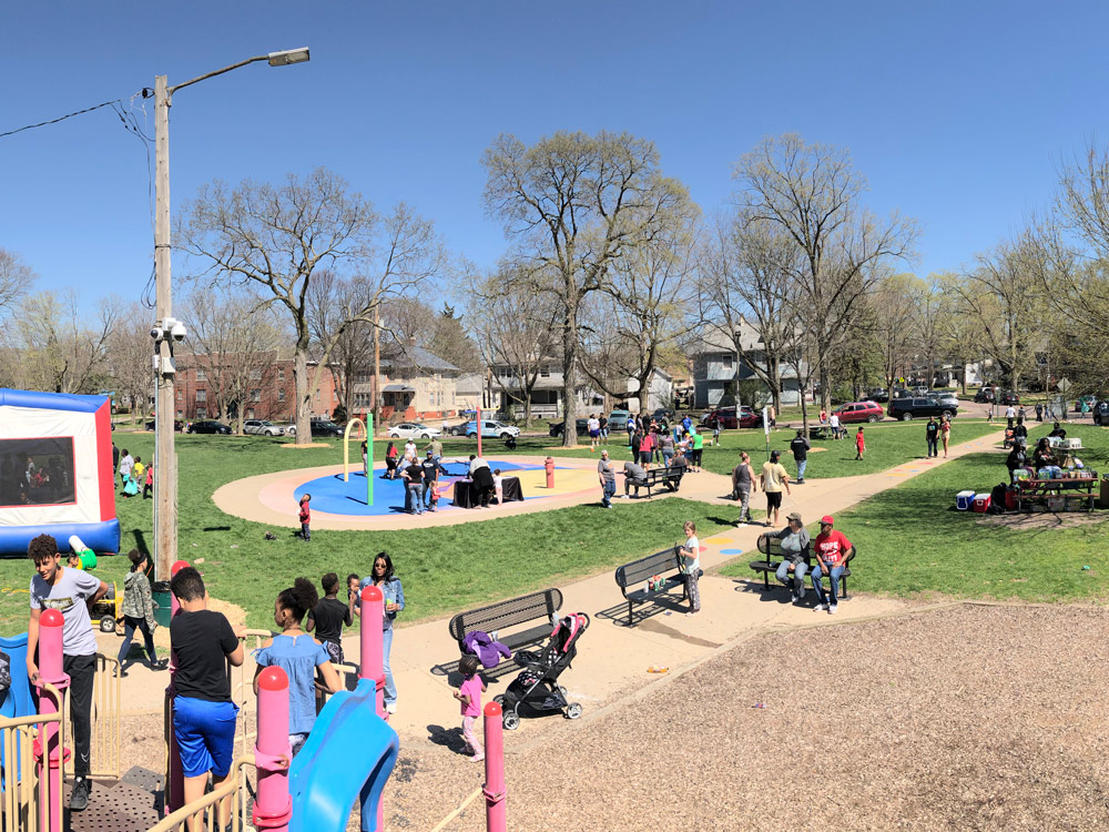 A large group of community members gather in the park.