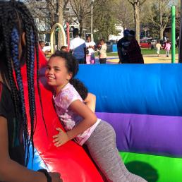 Two girls interact on a bouncing obstacle course